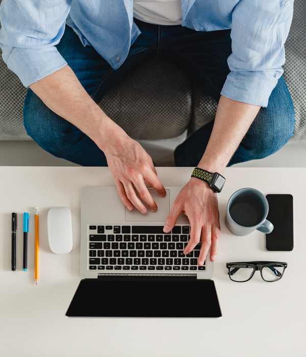 flat lay view from above on table workplace close-up man hands at home working typing on laptop online freelancer job, black empty screen, stationery